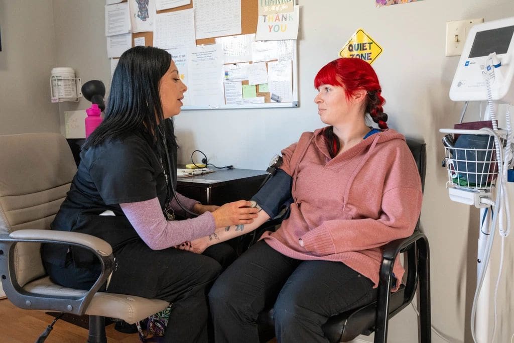 Nurse taking a blood pressure reading with a client